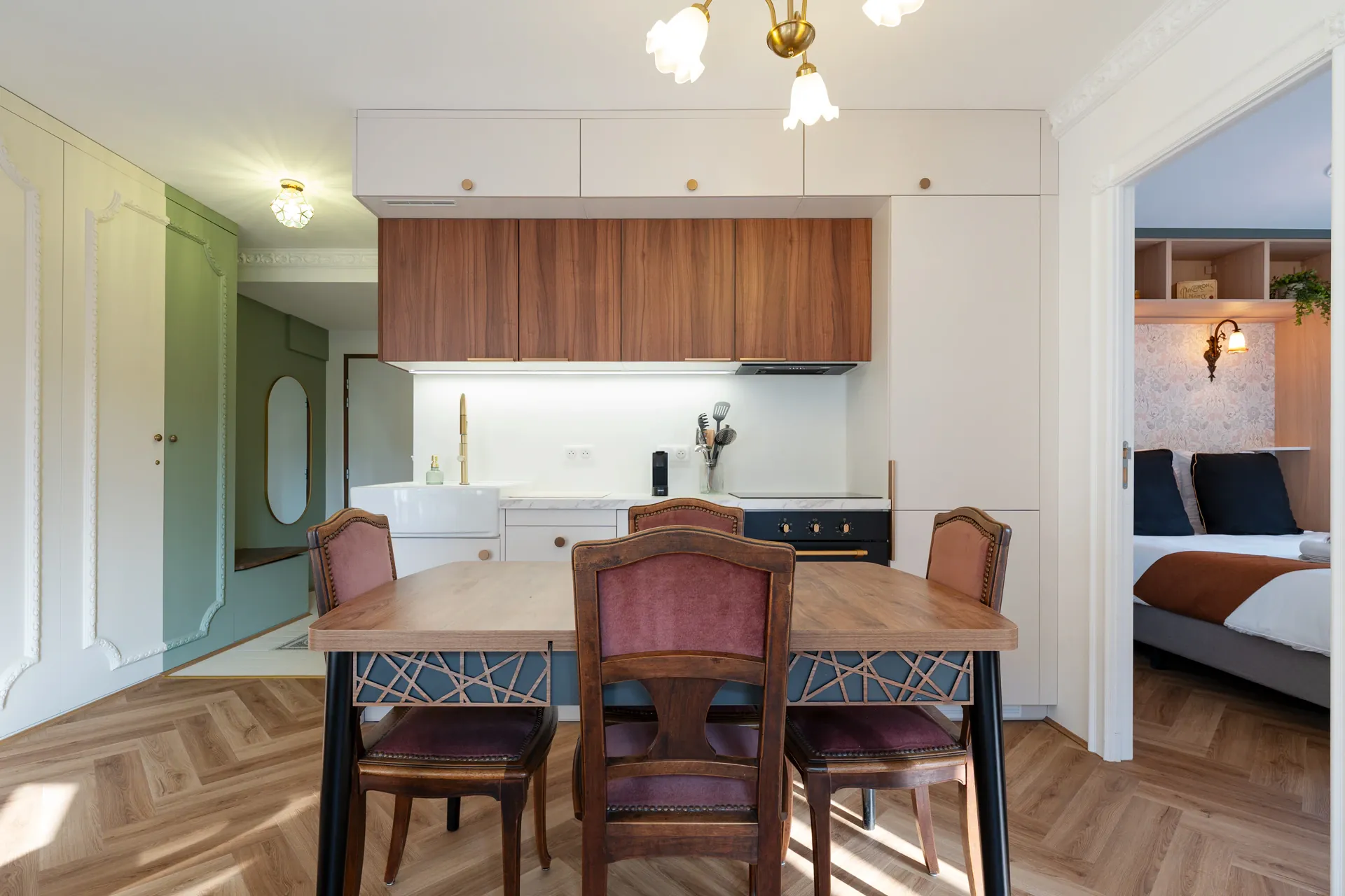 Cuisine ouverte sur la table à manger et ses chaises en velours